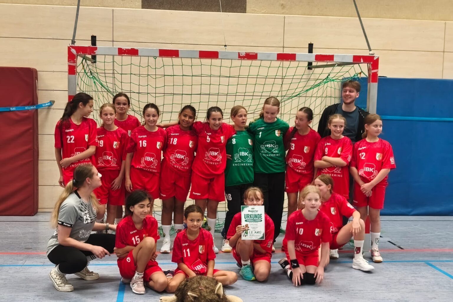 Jugendsportmannschaft in roten Trikots beim Gruppenfoto